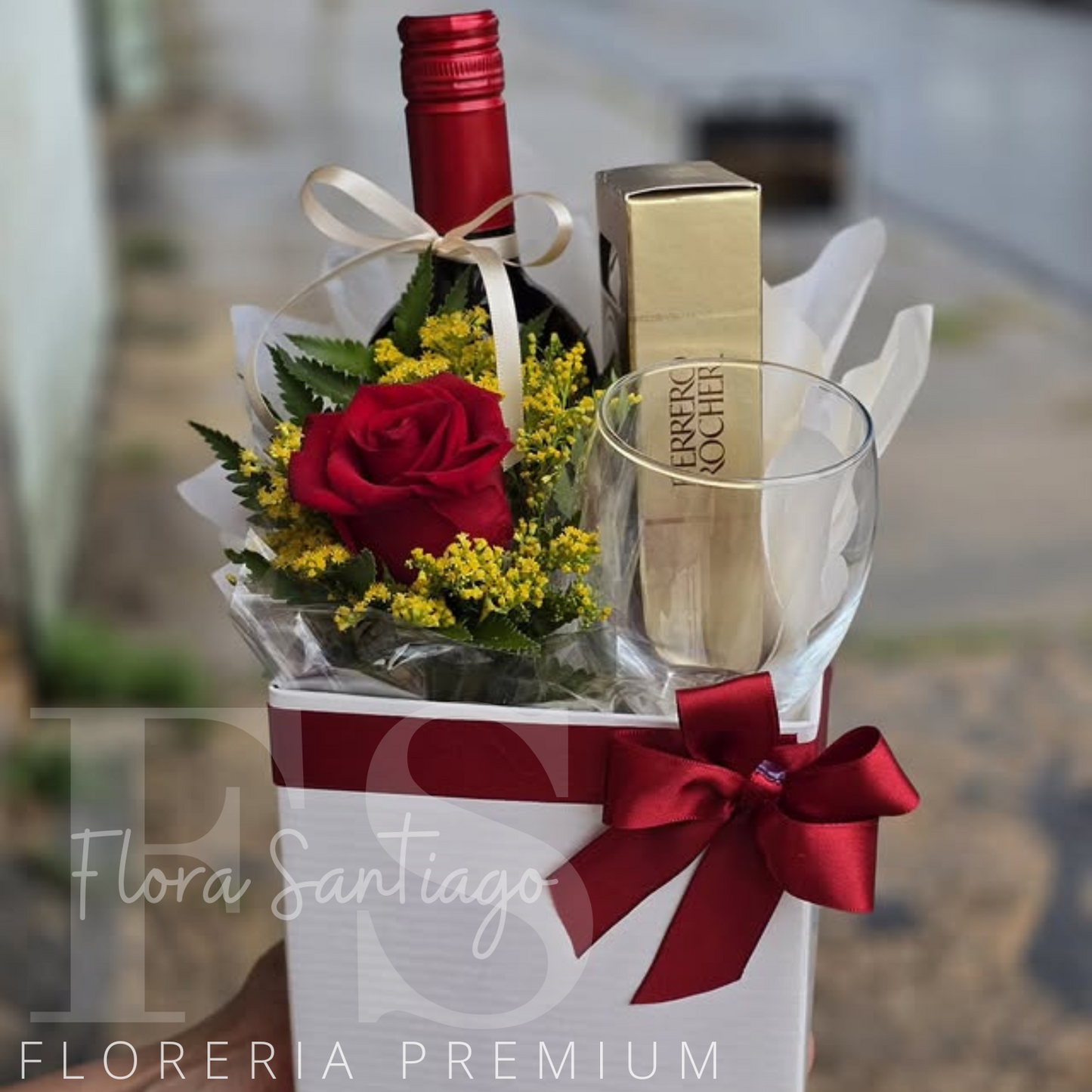 Box de una rosa, botella de vino tinto, copa de vino y caja de chocolate Ferrero Rocher
