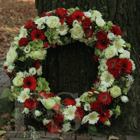 Corona fúnebre con rosas blancas y gerberas en color blanco verde y rojo arreglo de condolencias